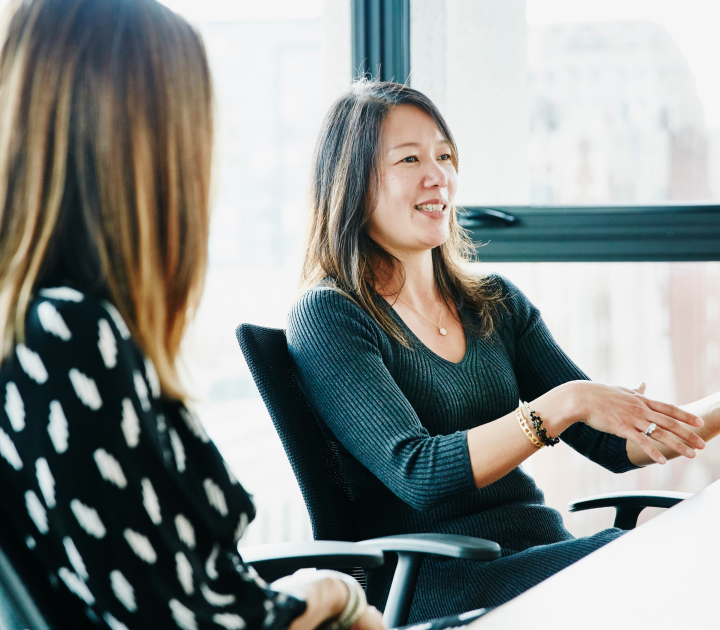 asian woman sitting at a conference table engaged in a meeting