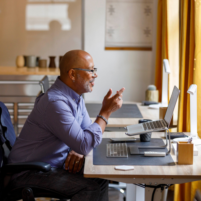 Man sitting at a desk on a video conference call on his laptop