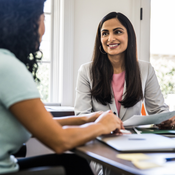 two women talking at a conference room table